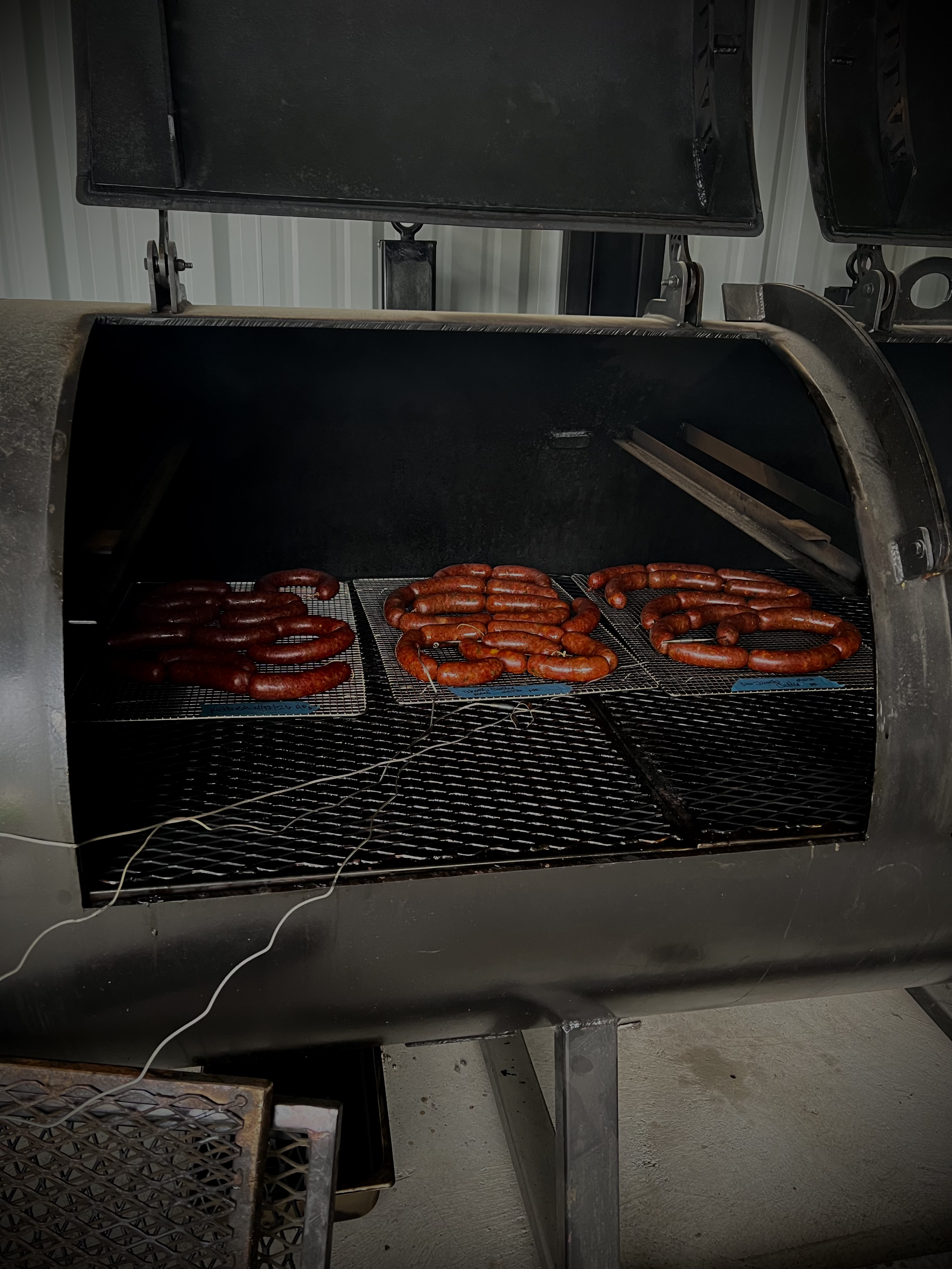 Homemade sausage links smoking on the pit